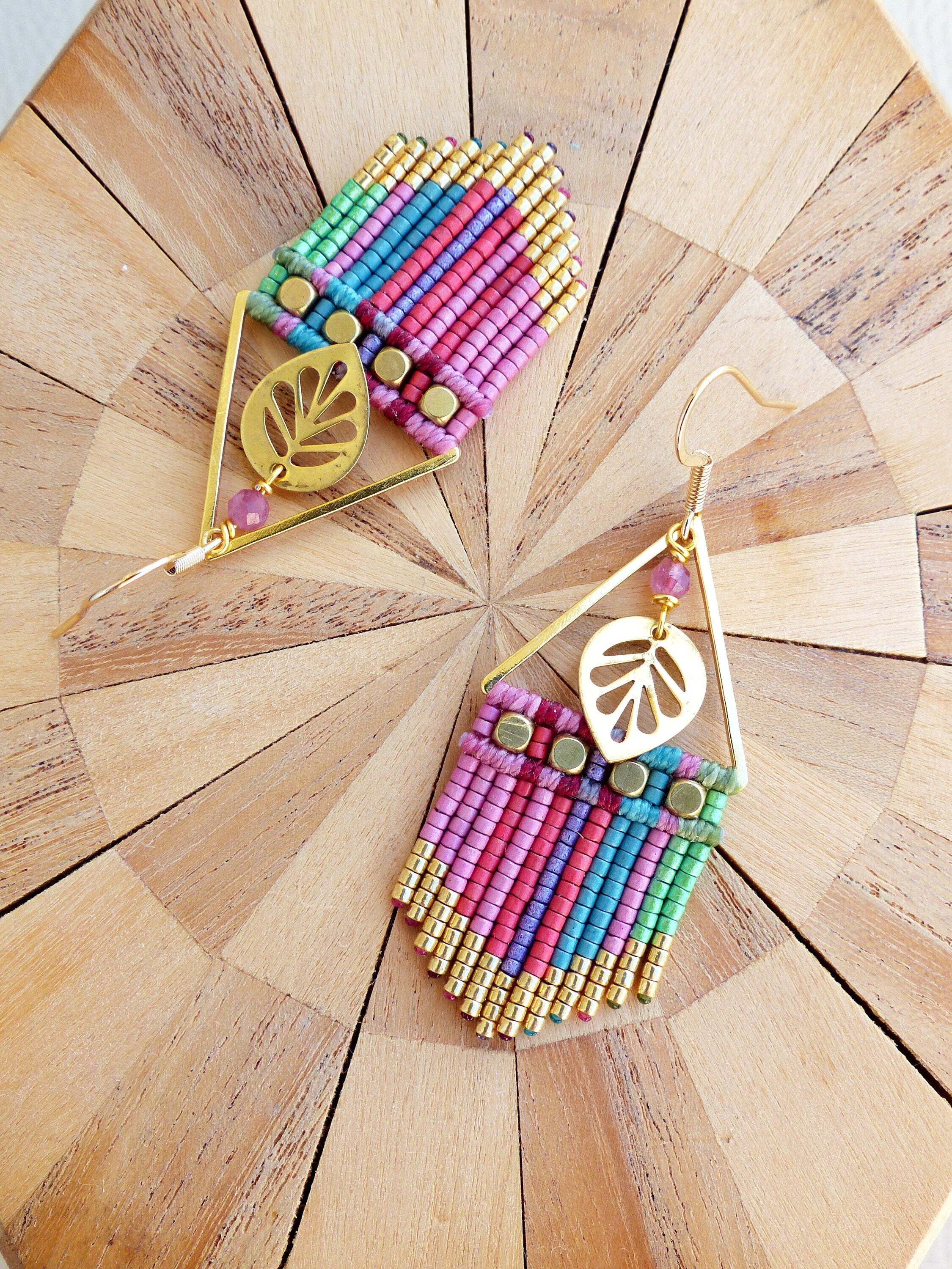Peut inclure: Une paire de boucles d'oreilles en or avec une frange de perles rose, verte et bleue et un charme en feuille d'or. 