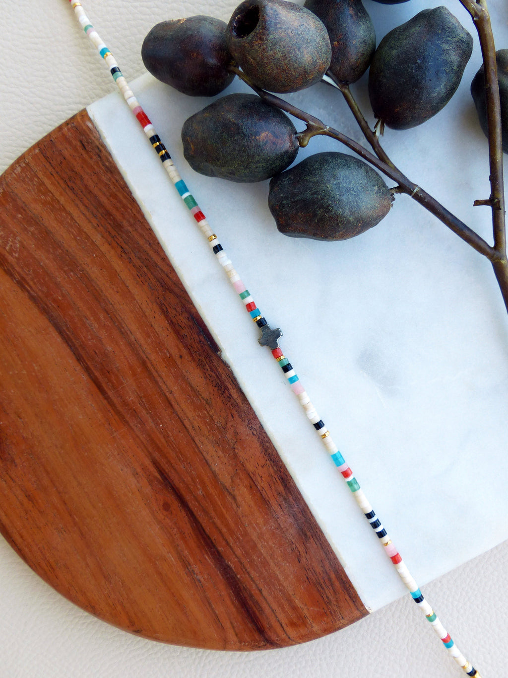 Peut inclure: Un bracelet en perles colorées avec un petit charme en forme d'étoile. Le bracelet est composé de perles blanches, noires, rouges, bleues et dorées.
