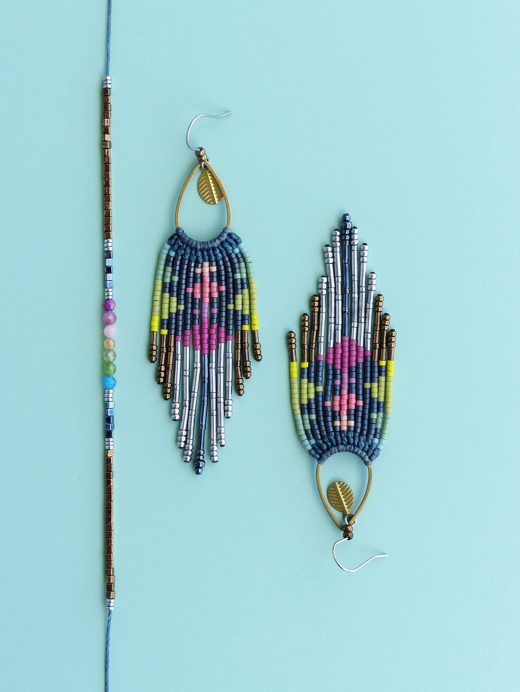 Peut inclure: Une paire de longues boucles d'oreilles en perles avec un charme en forme de feuille et un bracelet en perles assorti. Les boucles d'oreilles et le bracelet sont faits de perles bleues, argentées, dorées, roses et vertes.
