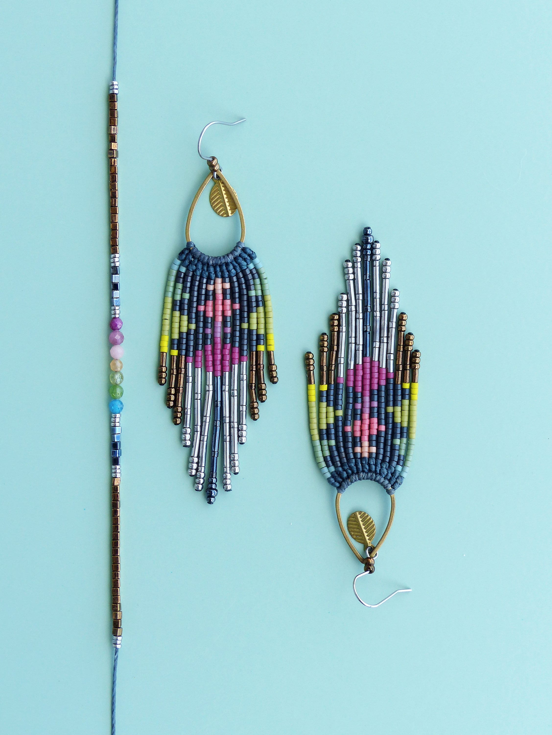 Peut inclure: Une paire de longues boucles d'oreilles en perles avec un charme en forme de feuille et un bracelet en perles assorti. Les boucles d'oreilles et le bracelet sont faits de perles bleues, argentées, dorées, roses et vertes.