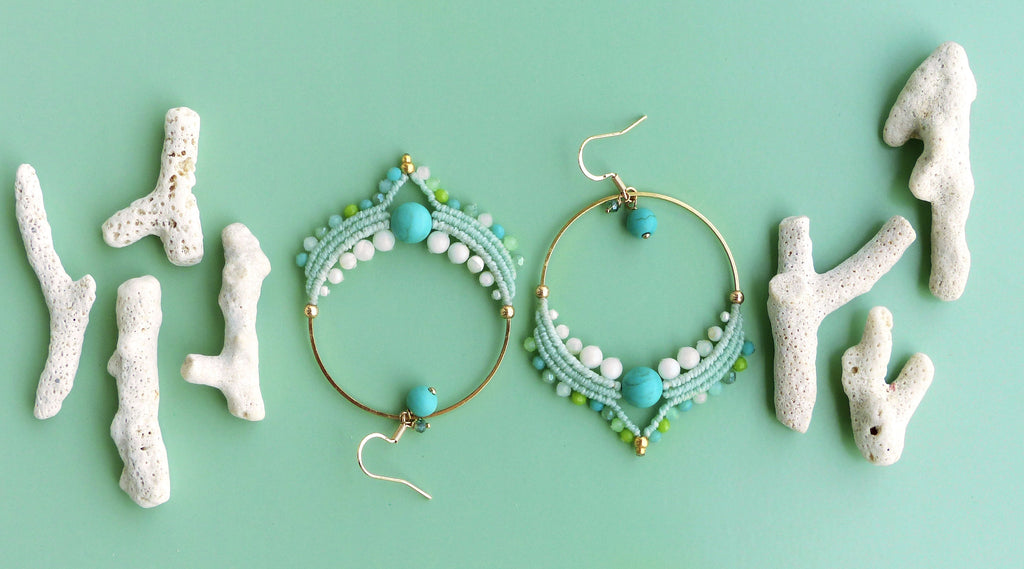 Peut inclure: Boucles d'oreilles macramé faites à la main avec des perles turquoise et blanches, accentuées de métal doré. Les boucles d'oreilles sont présentées avec des morceaux de corail blanc sur un fond vert clair. Style bohème et plage.