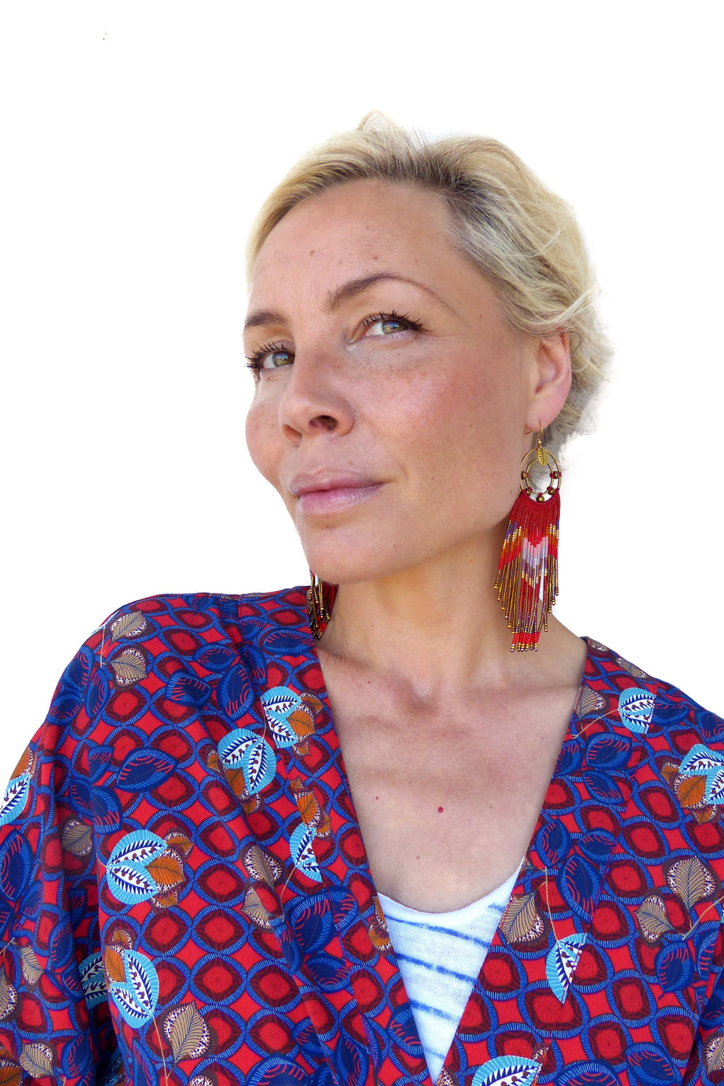 Peut inclure: Une femme aux cheveux blonds portant un kimono à motifs rouge et bleu avec de longues boucles d'oreilles en perles rouges et dorées.