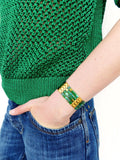 Peut inclure: Un bracelet vert et or avec un motif géométrique. Le bracelet est composé de petites tuiles carrées disposées en un motif répétitif. Les tuiles sont un mélange de vert et d'or, et le bracelet est sécurisé par un fermoir en or.