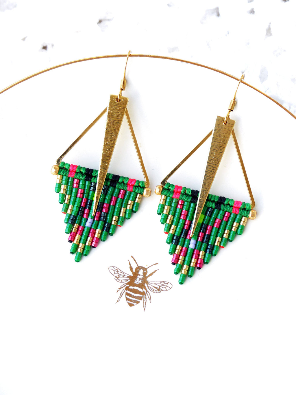 Peut inclure: Une paire de boucles d'oreilles triangulaires dorées avec des franges de perles vertes, roses, noires et dorées.