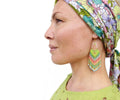 Peut inclure: Une femme portant un bandeau floral et des boucles d'oreilles en perles vertes. Les boucles d'oreilles sont longues et pendantes, avec un mélange de perles vertes, bleues et roses.