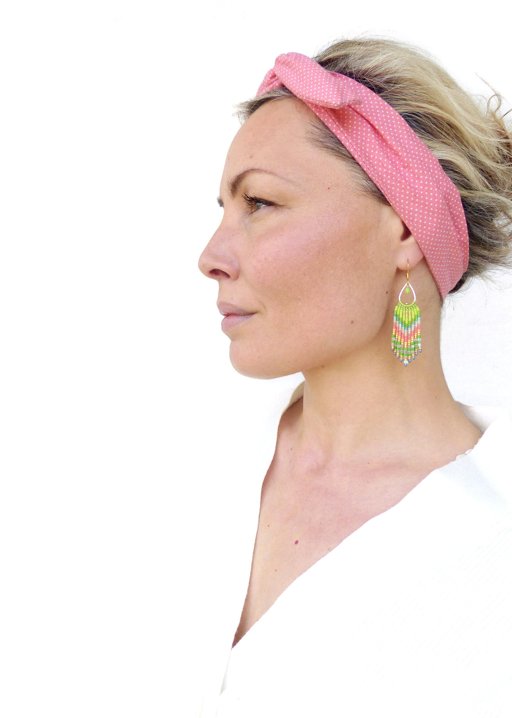 Peut inclure: Une femme portant un bandeau rose à pois blancs et des boucles d'oreilles en perles vertes et roses. 