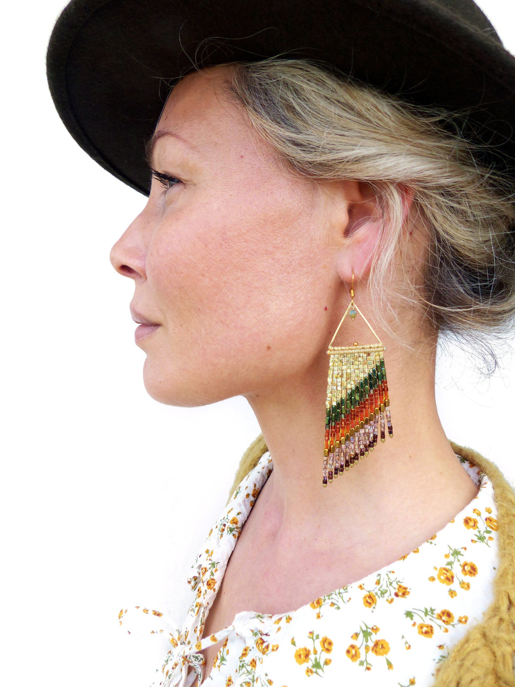 Peut inclure: Une paire de longues boucles d'oreilles en perles avec un motif de triangle doré. Les boucles d'oreilles présentent un dégradé de couleurs, notamment le vert, l'orange et le violet.