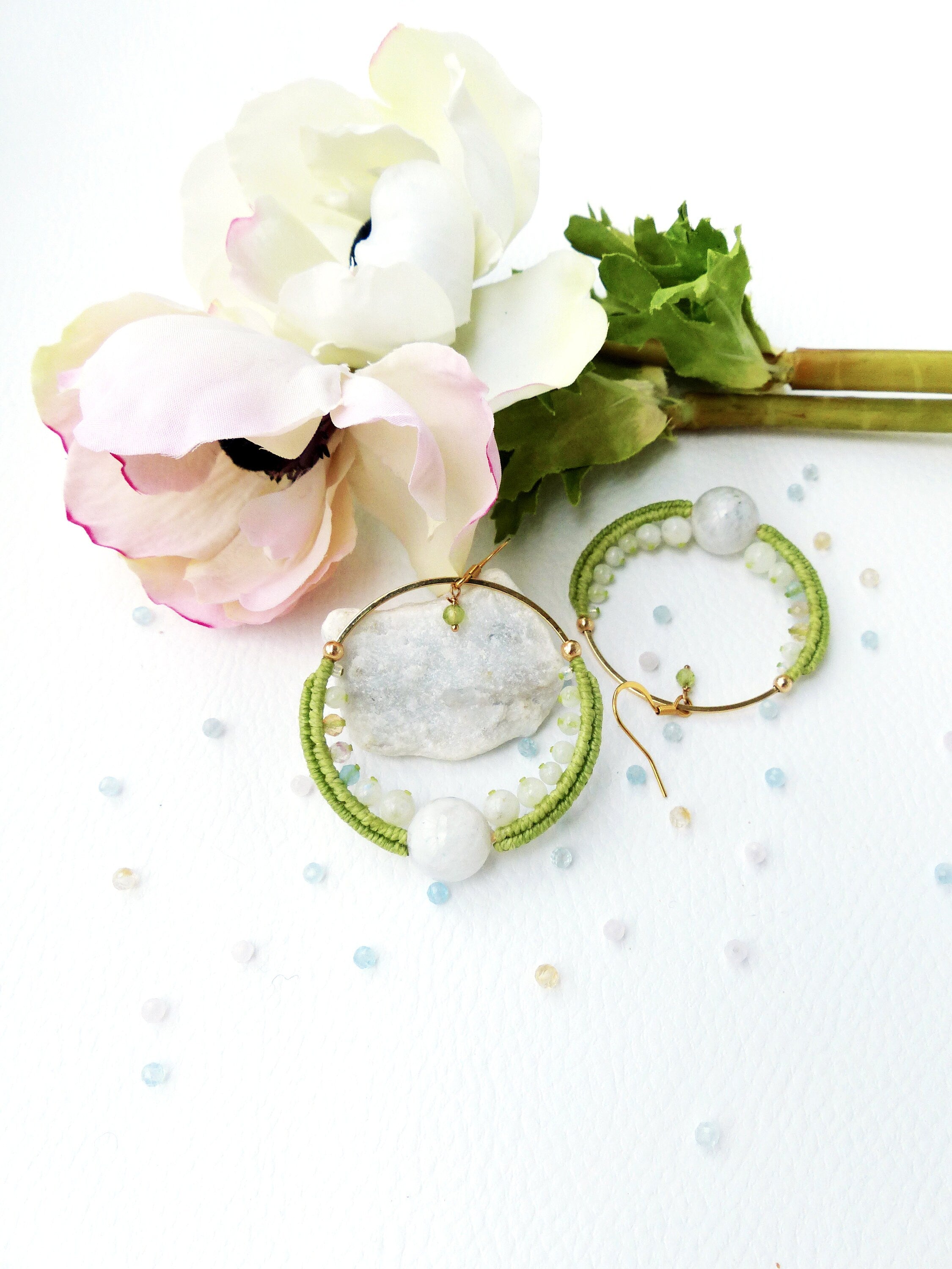 Peut inclure: Une paire de boucles d'oreilles créoles en perles vertes et blanches avec un cadre en fil d'or. Les boucles d'oreilles présentent une grosse perle blanche et des perles vertes et blanches plus petites.