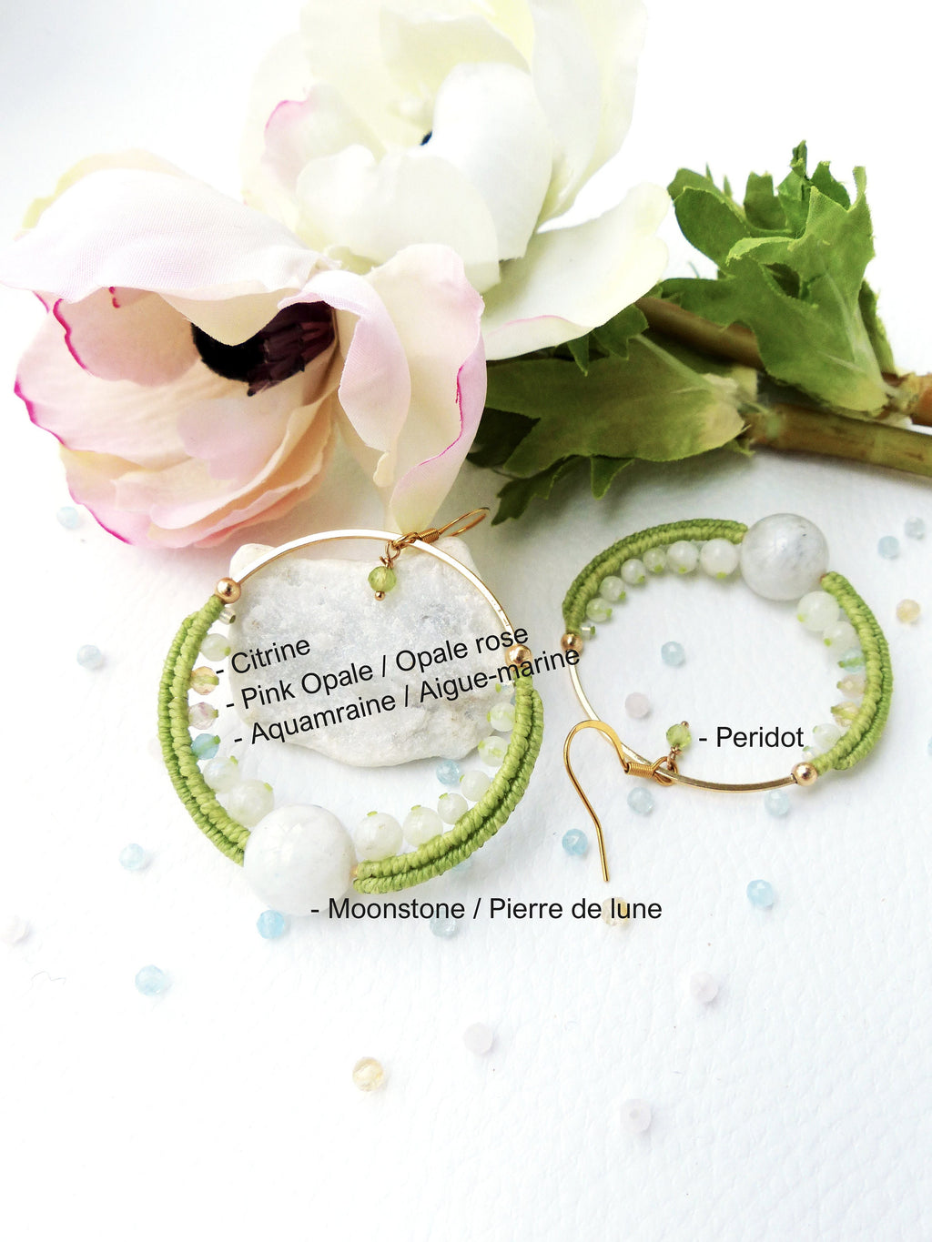 Peut inclure: Une paire de boucles d'oreilles créoles en or et vert avec différentes pierres précieuses, dont de la citrine, de l'opale rose, de l'aigue-marine, de la pierre de lune et du péridot. Les boucles d'oreilles sont faites à la main et présentent un design unique.