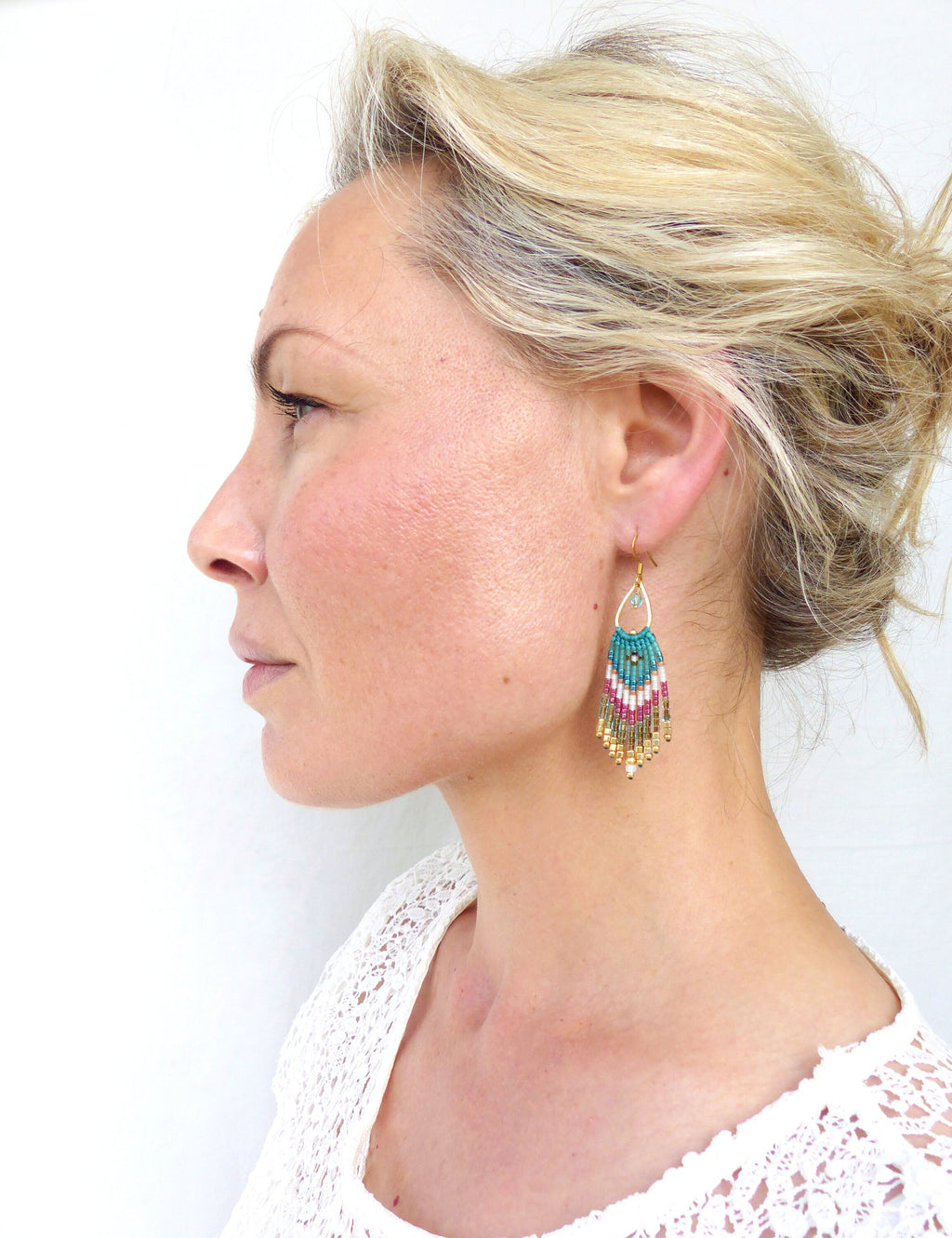 Peut inclure: Une paire de boucles d'oreilles pendantes en perles turquoise, rose et or. Les boucles d'oreilles sont faites de petites perles et ont une forme de larme.