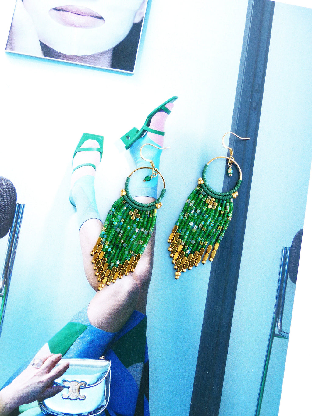 Peut inclure: Une paire de boucles d'oreilles pendantes en perles vertes et dorées. Les boucles d'oreilles sont faites de petites perles rondes et ont un anneau doré en haut.