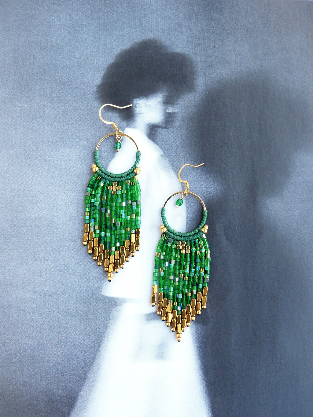 Peut inclure: Boucles d'oreilles en perles vertes et dorées avec un design en frange. Les boucles d'oreilles sont faites de petites perles rondes et de métal doré.