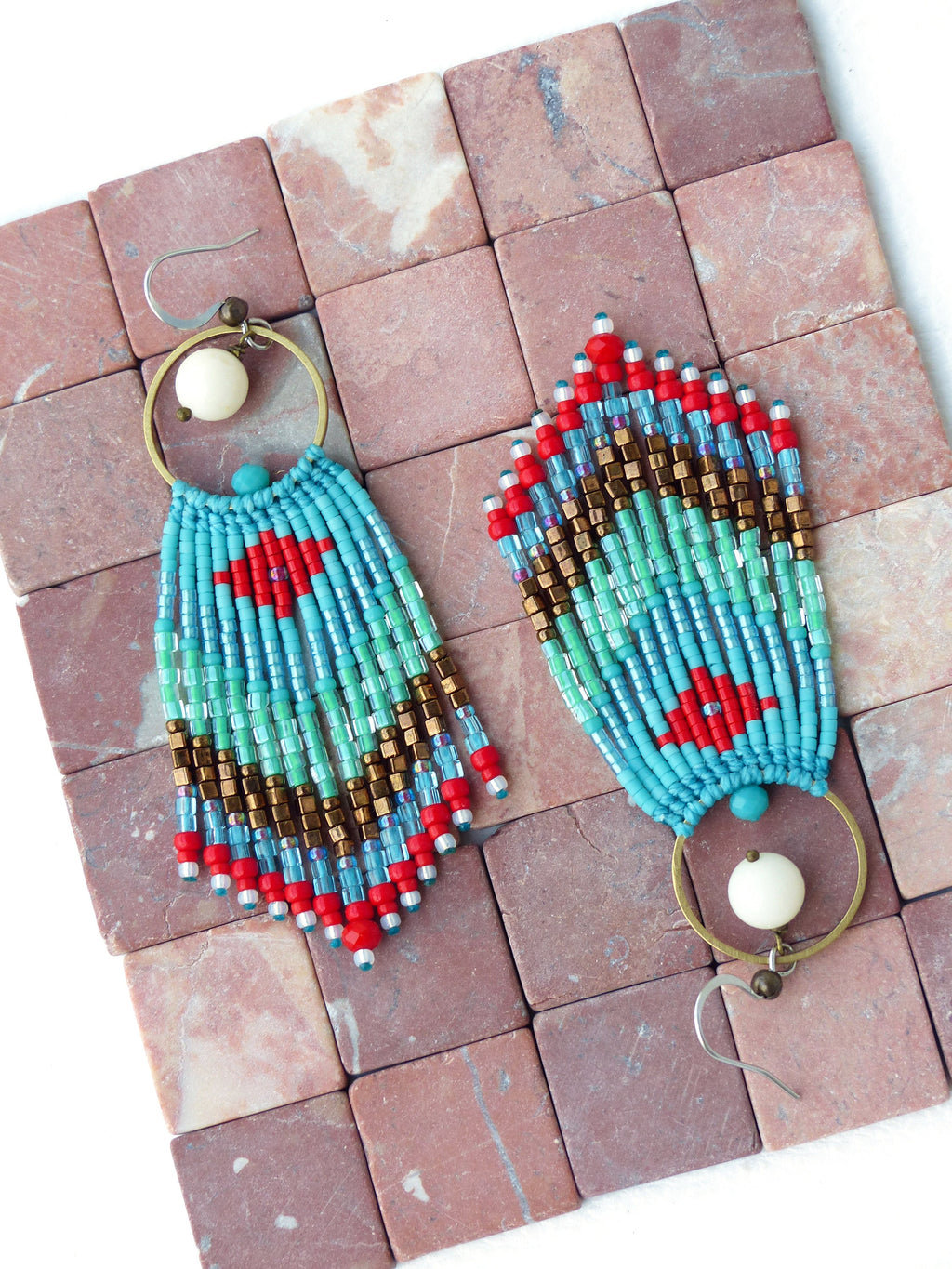 Peut inclure: Une paire de boucles d'oreilles pendantes en perles turquoise, rouge et or avec des accents de perles blanches et des cercles en laiton.