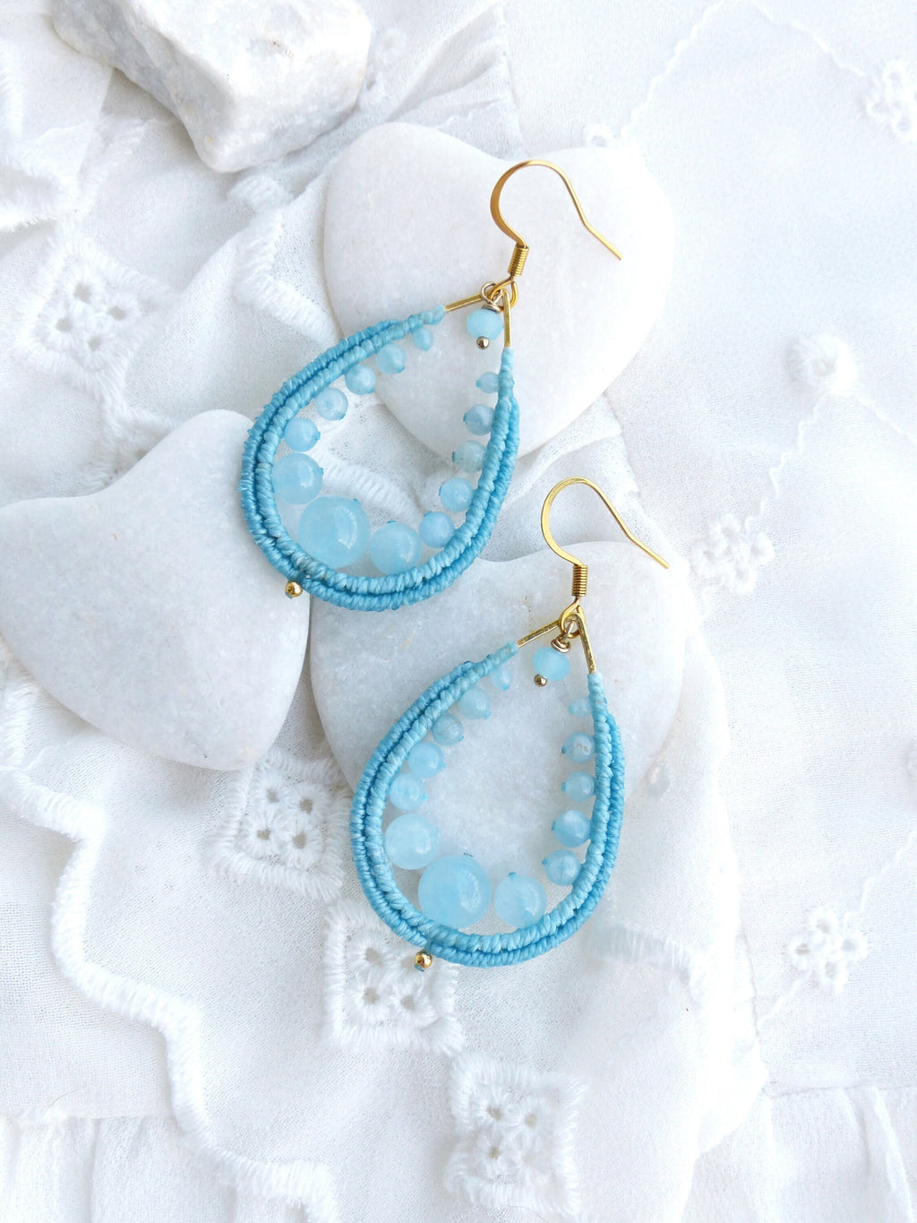 Peut inclure: Une paire de boucles d'oreilles en forme de goutte d'eau avec un fil d'or enroulé de perles bleu clair et des accents de pierres précieuses bleu clair.