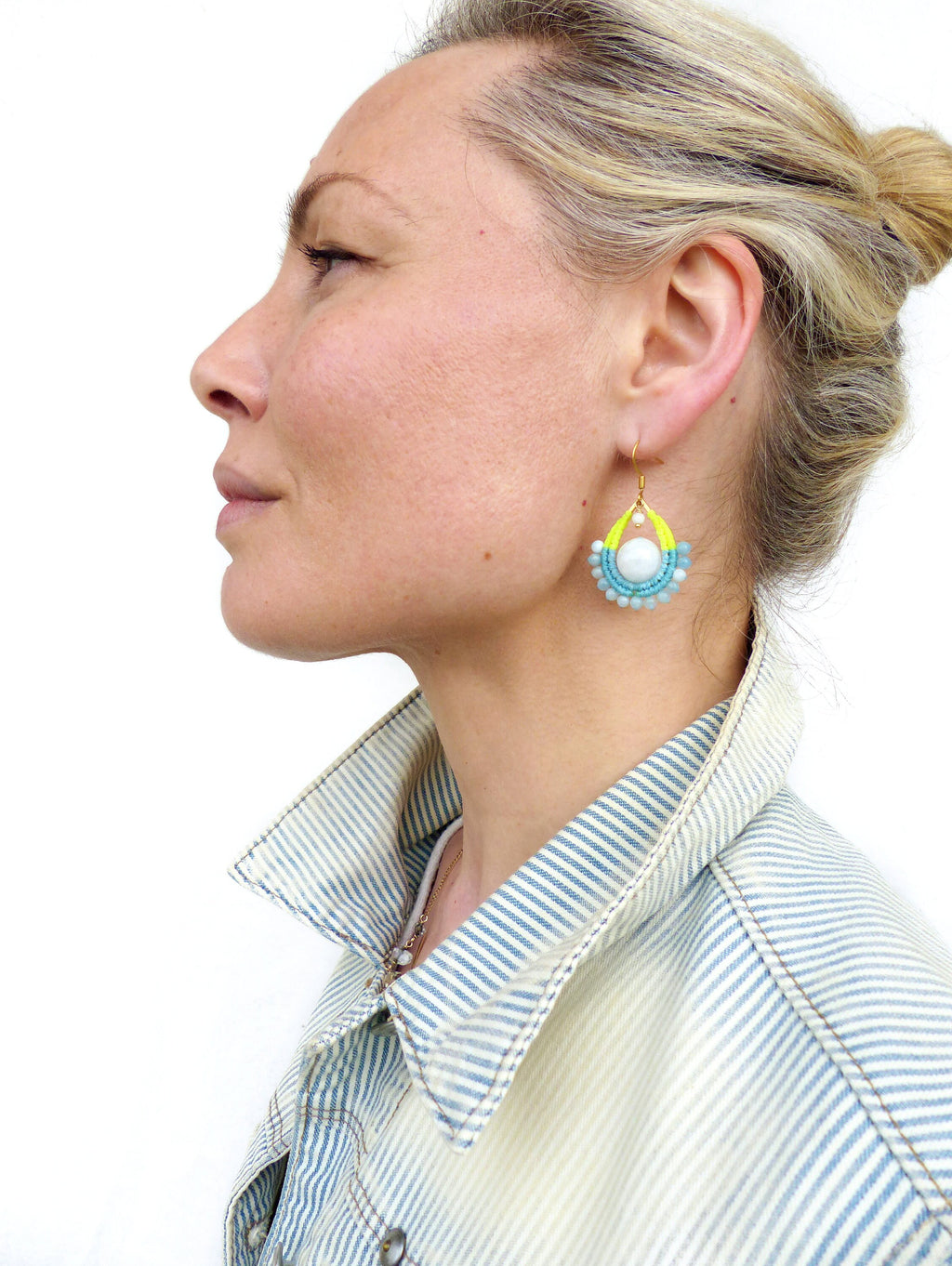 Peut inclure: Une paire de boucles d'oreilles pendantes avec un centre de perle blanche et des perles bleues et jaunes. Les boucles d'oreilles sont faites de fil d'or et ont une forme de larme.