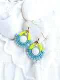 Peut inclure: Une paire de boucles d'oreilles pendantes avec une pierre blanche entourée de perles bleues et jaunes.
