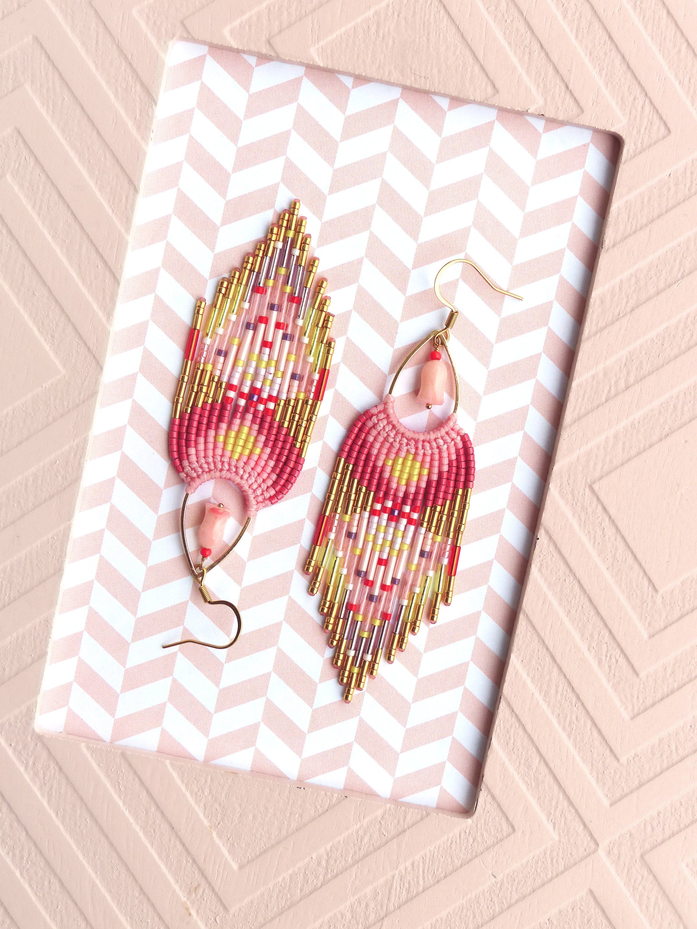 Peut inclure: Une paire de boucles d'oreilles en perles roses, jaunes et dorées avec un accent de pierre rose. Les boucles d'oreilles ont la forme d'une larme et présentent un design en frange.
