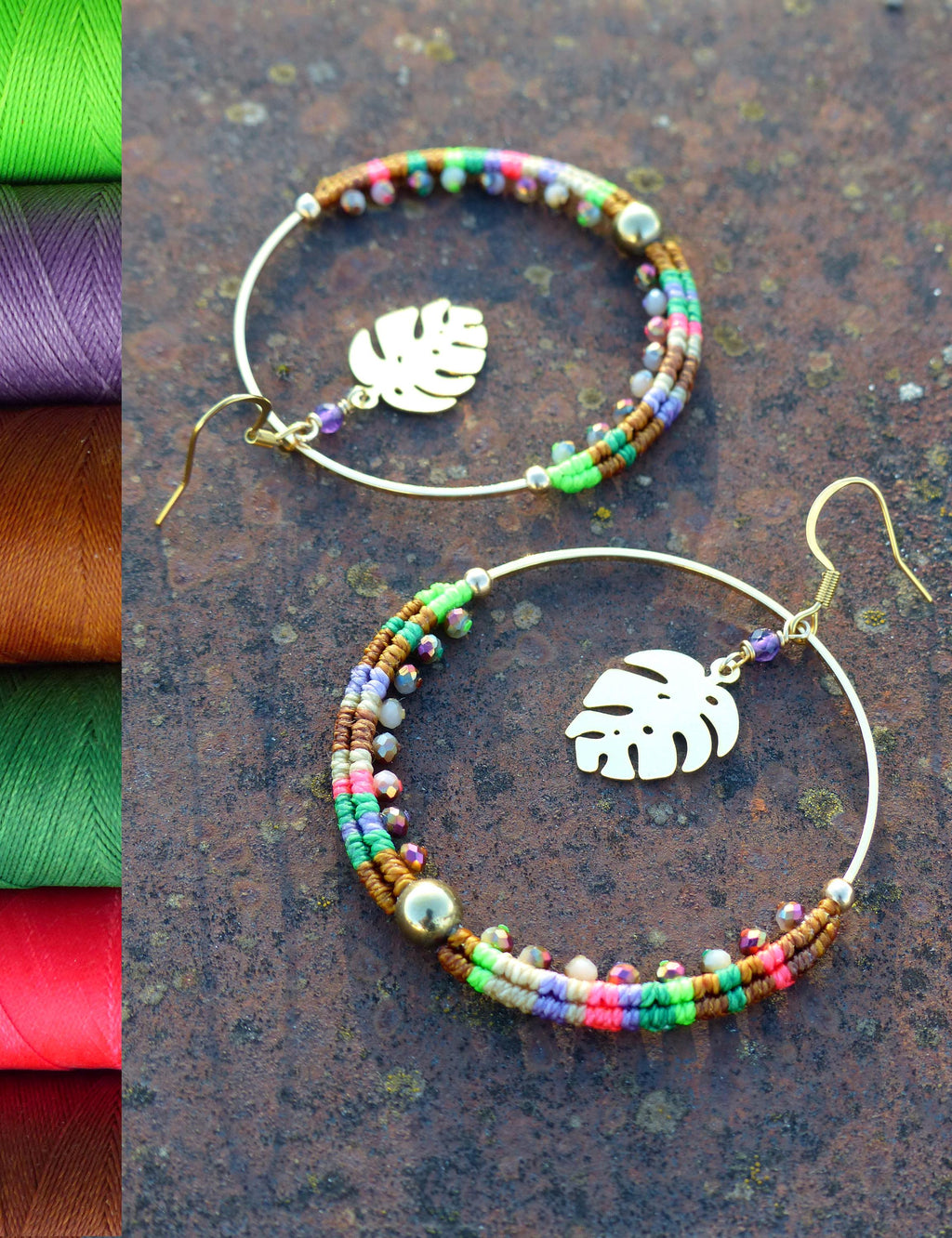 Peut inclure: Une paire de boucles d'oreilles créoles dorées avec un design de perles multicolores. Chaque boucle d'oreille est ornée d'un petit charme en forme de feuille d'or.