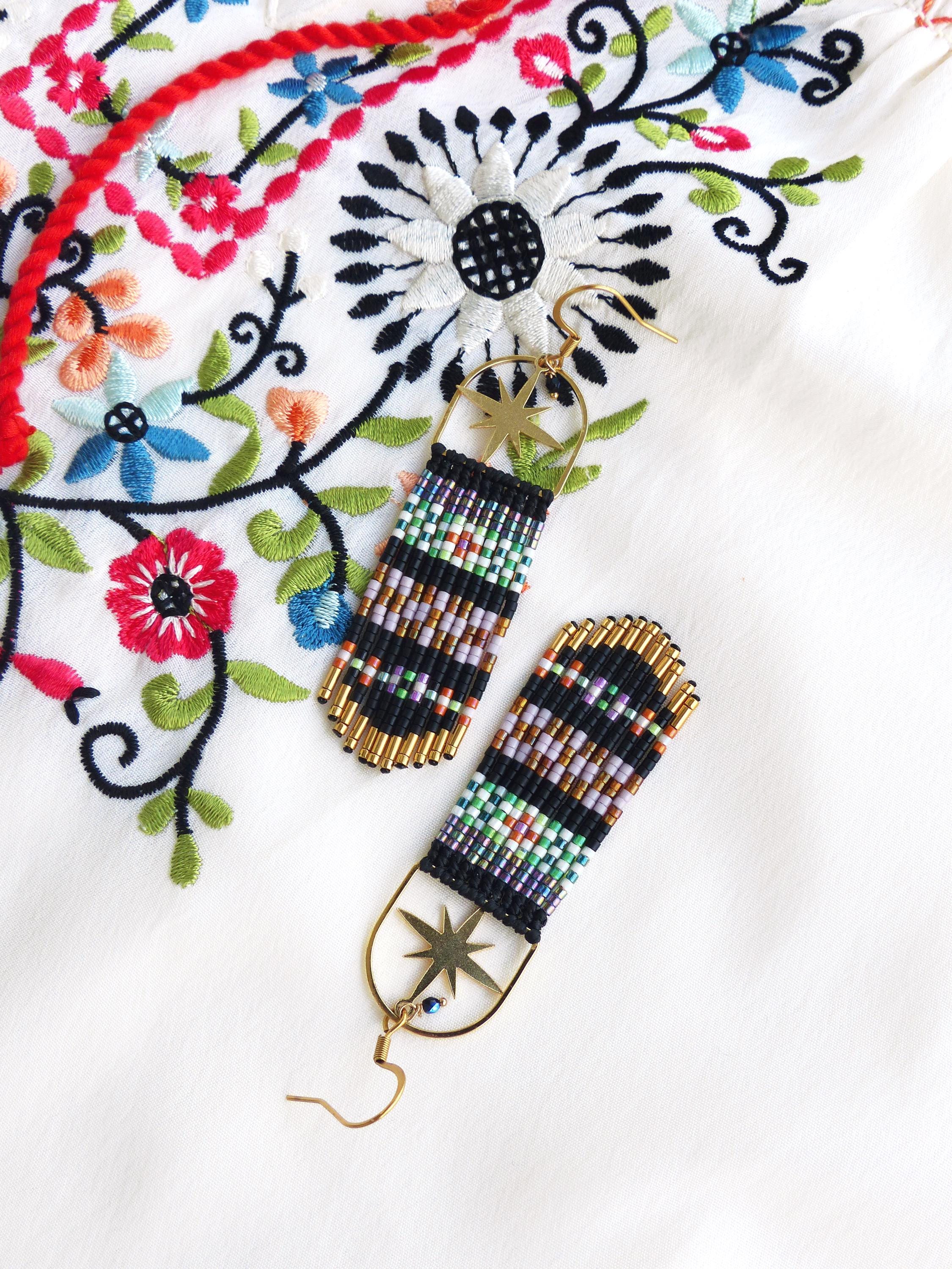 Peut inclure: Une paire de longues boucles d'oreilles en perles avec un charme d'étoile dorée et une perle bleue de mauvais œil. Les boucles d'oreilles sont noires, blanches et multicolores.