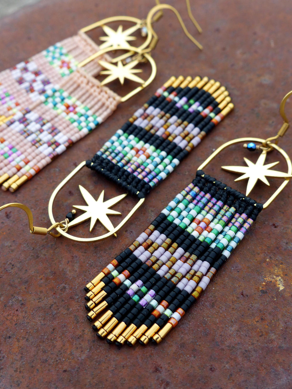 Peut inclure: Une paire de longues boucles d'oreilles en perles avec des breloques en forme d'étoile dorée. Les boucles d'oreilles sont faites de perles noires, blanches et roses, et ont un design en forme de frange.