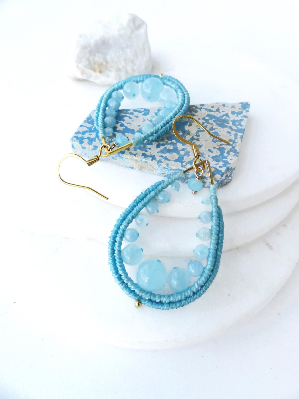 Peut inclure: Une paire de boucles d'oreilles pendantes en forme de larme. Les boucles d'oreilles sont faites de perles bleu clair et de fil d'or. 
