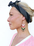 Peut inclure: Une paire de longues boucles d'oreilles en perles colorées avec un motif géométrique. Les boucles d'oreilles sont faites de petites perles colorées et ont un crochet doré.