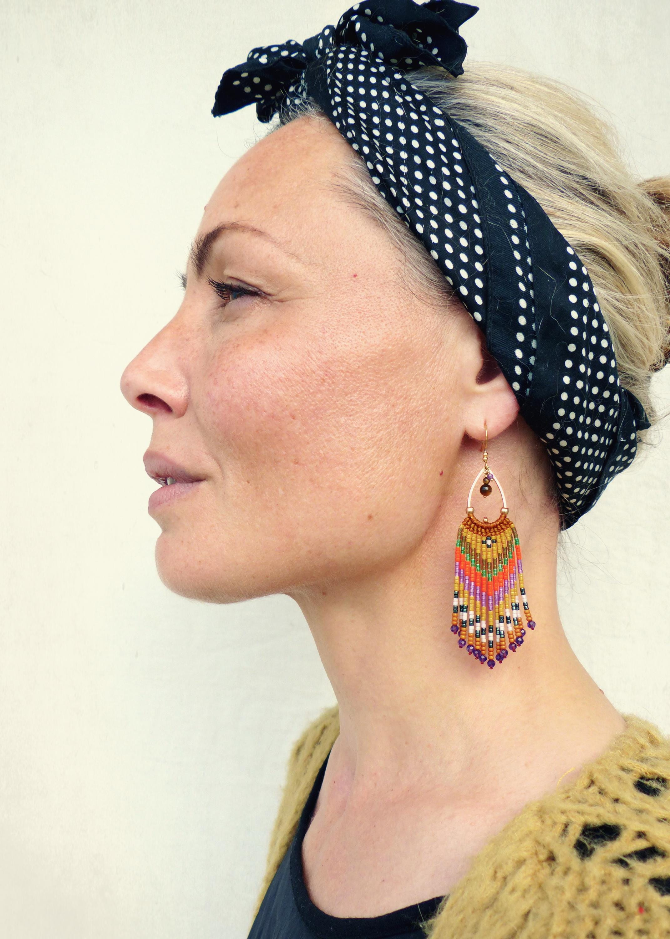 Peut inclure: Une paire de longues boucles d'oreilles en perles colorées avec un motif géométrique. Les boucles d'oreilles sont faites de petites perles colorées et ont un design en forme de glands. Les boucles d'oreilles pendent à l'oreille d'une personne.