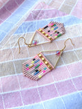Peut inclure: Boucles d'oreilles faites à la main avec un design géométrique. Les boucles d'oreilles présentent une frange de perles roses, des accents en métal doré et des perles colorées. Chaque boucle d'oreille a un crochet doré et un petit cristal irisé.