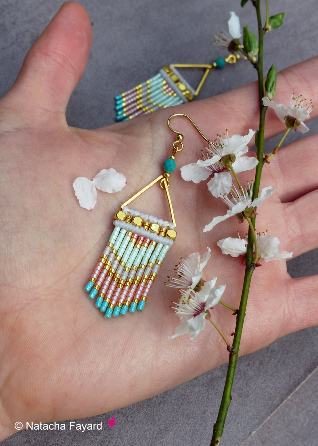 Peut inclure: Une paire de boucles d'oreilles en forme de triangle doré avec une perle turquoise et une frange de perles roses, blanches et turquoise.