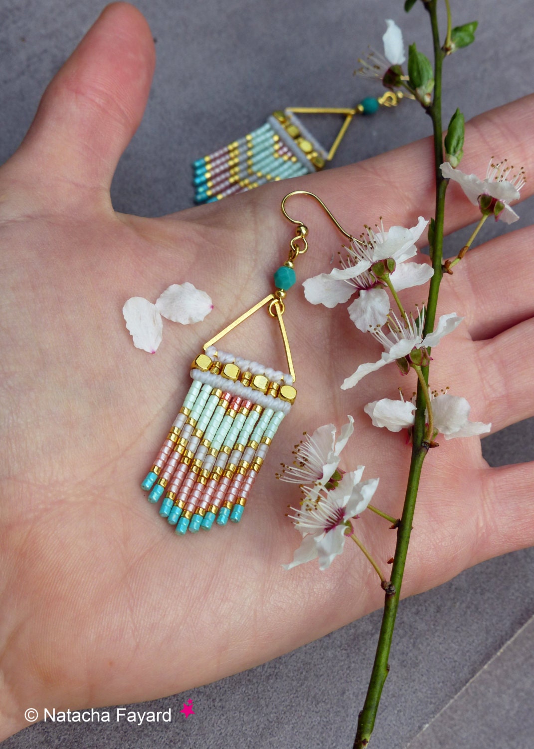 Peut inclure: Une paire de boucles d'oreilles en forme de triangle doré avec une perle turquoise et une frange de perles roses, blanches et turquoise.