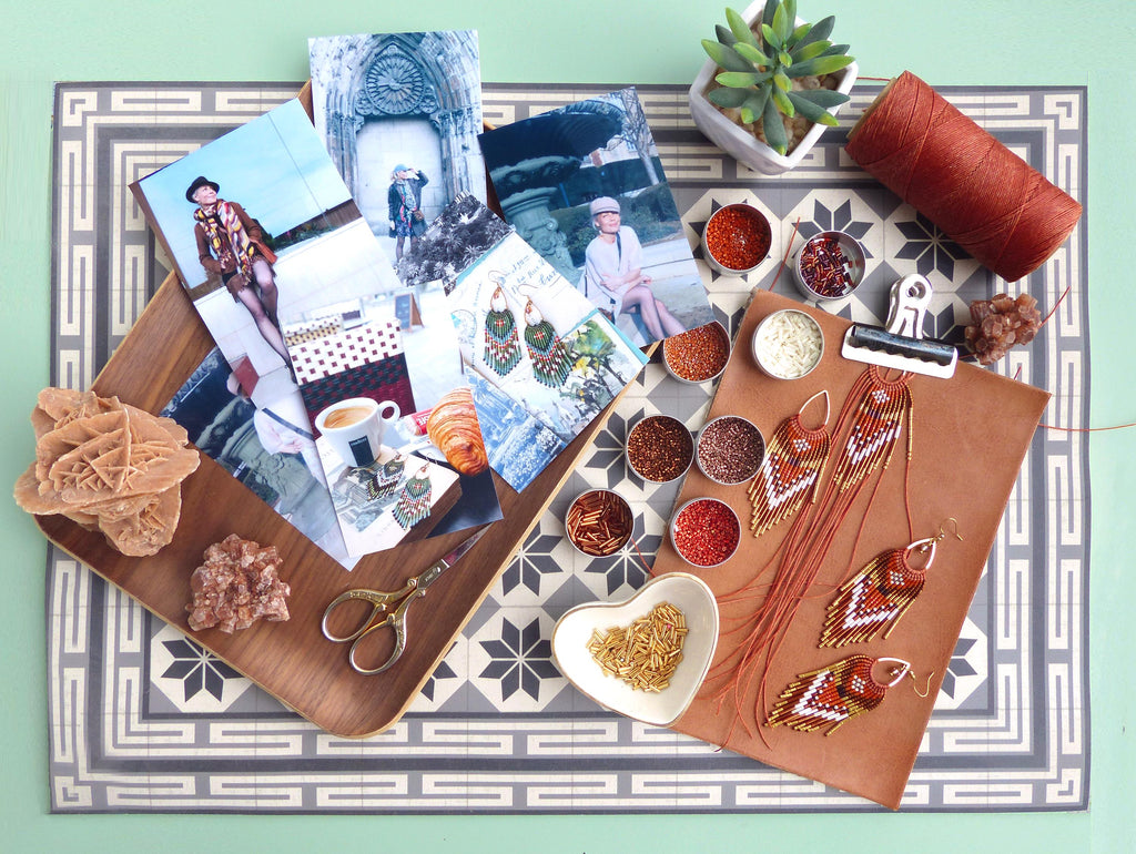 Peut inclure: Composition à plat avec un plateau en bois contenant des photos, un presse-papiers en cuir marron avec des boucles d'oreilles perlées, de petits bols de perles, une bobine de fil et une petite plante succulente. Fond à motifs.
