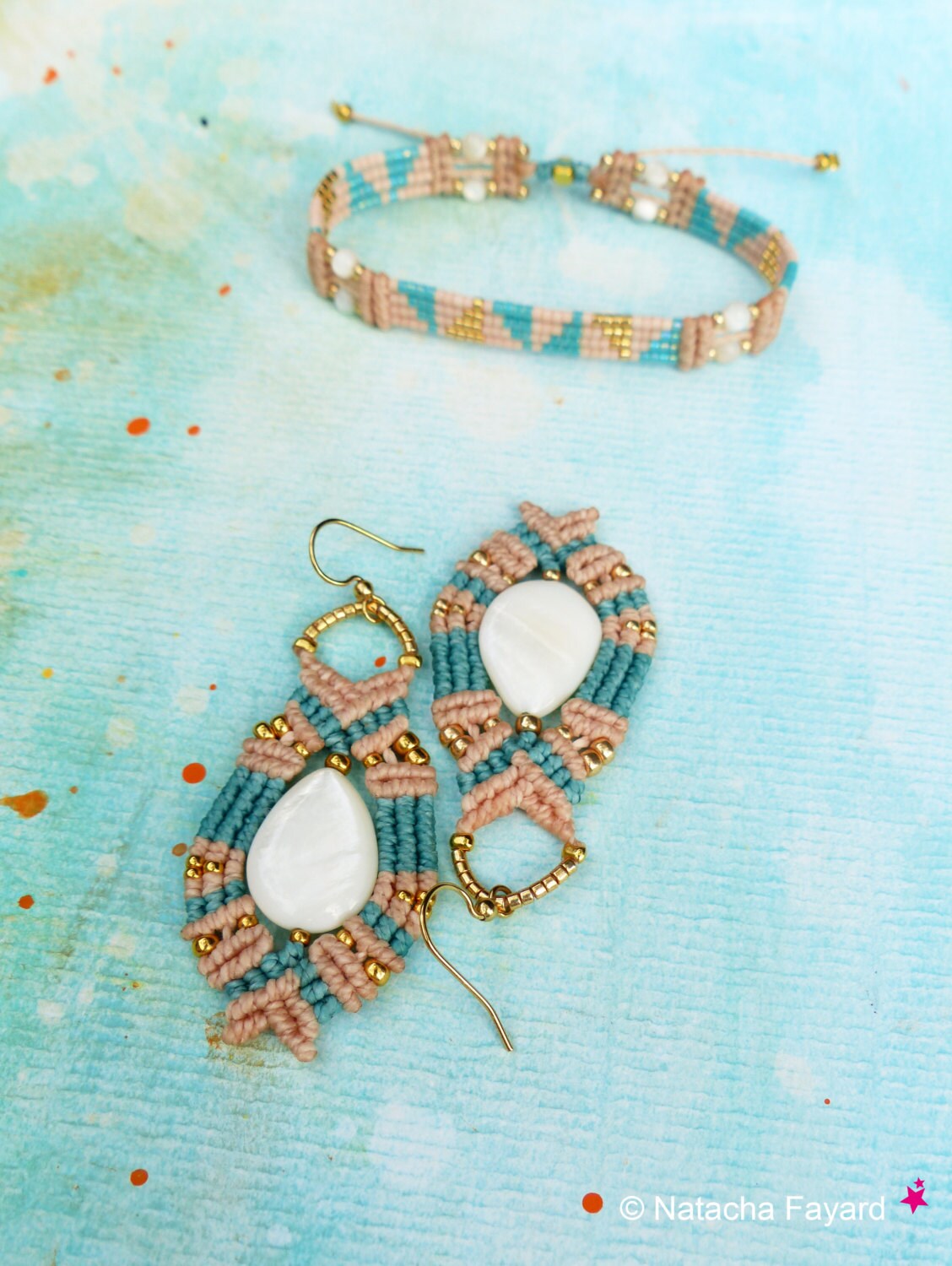 Peut inclure: Un ensemble de bijoux faits main comprenant un bracelet en macramé turquoise et rose et une paire de boucles d'oreilles avec des accents de coquillages blancs. Les bijoux sont réalisés avec une technique de nouage et ont un style bohème.