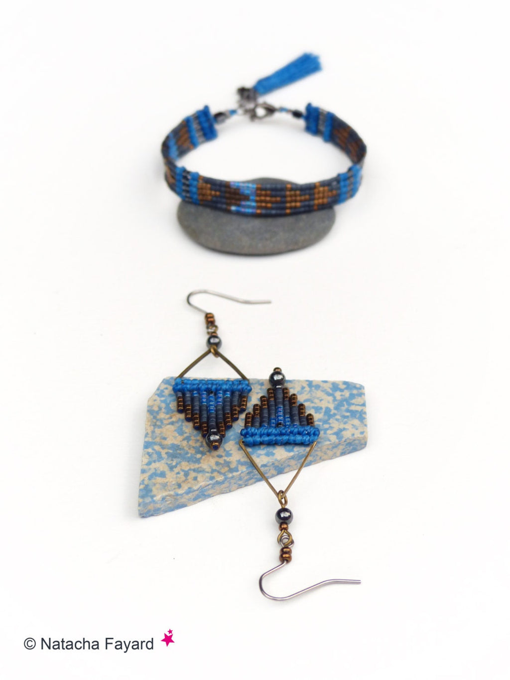 Peut inclure: Un ensemble de bijoux en perles bleues et brunes comprenant un bracelet avec un pompon et une paire de boucles d'oreilles triangulaires.