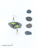 Peut inclure: Une paire de boucles d'oreilles triangulaires géométriques avec des perles noires, brunes et vertes. Les boucles d'oreilles sont suspendues à un crochet argenté.