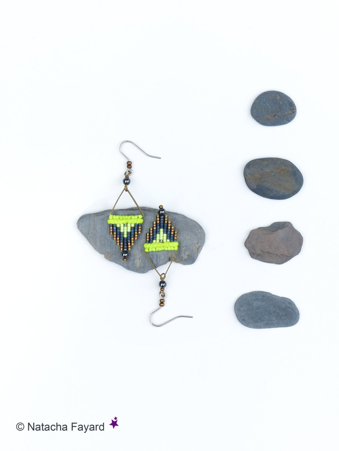 Peut inclure: Une paire de boucles d'oreilles triangulaires géométriques avec des perles noires, brunes et vertes. Les boucles d'oreilles sont suspendues à un crochet argenté.