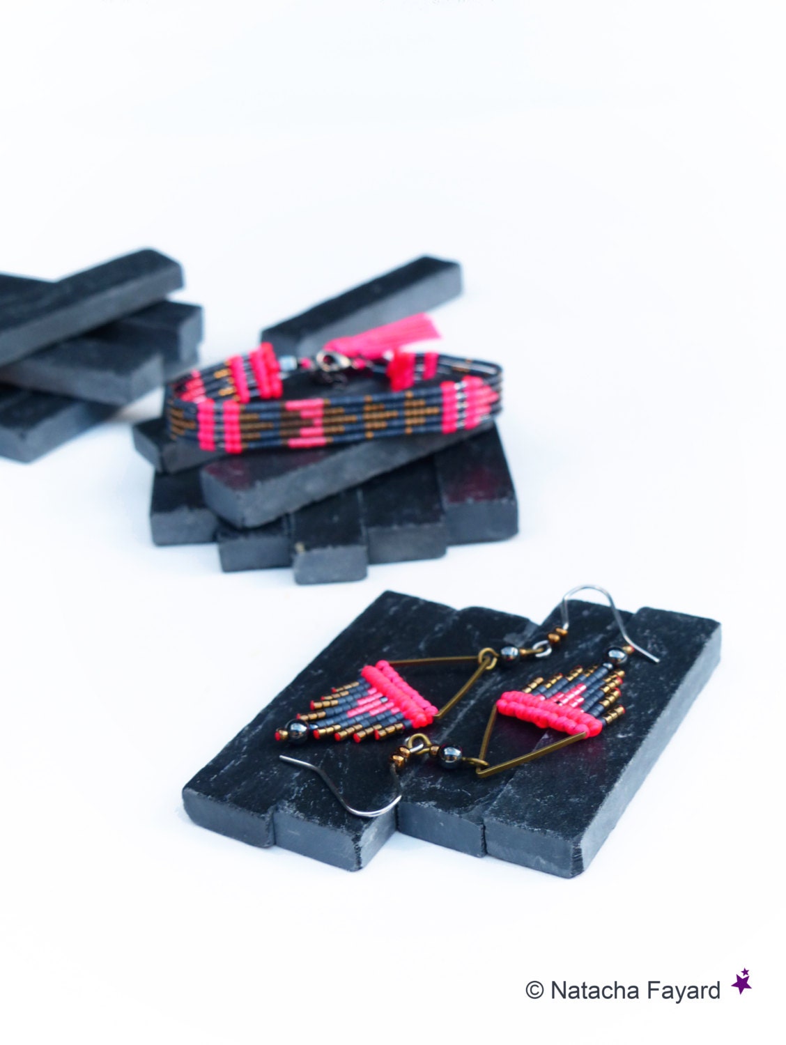 Peut inclure: Un ensemble de boucles d'oreilles et un bracelet assortis en perles noires et roses. Les bijoux sont présentés sur des carreaux de schiste noir.