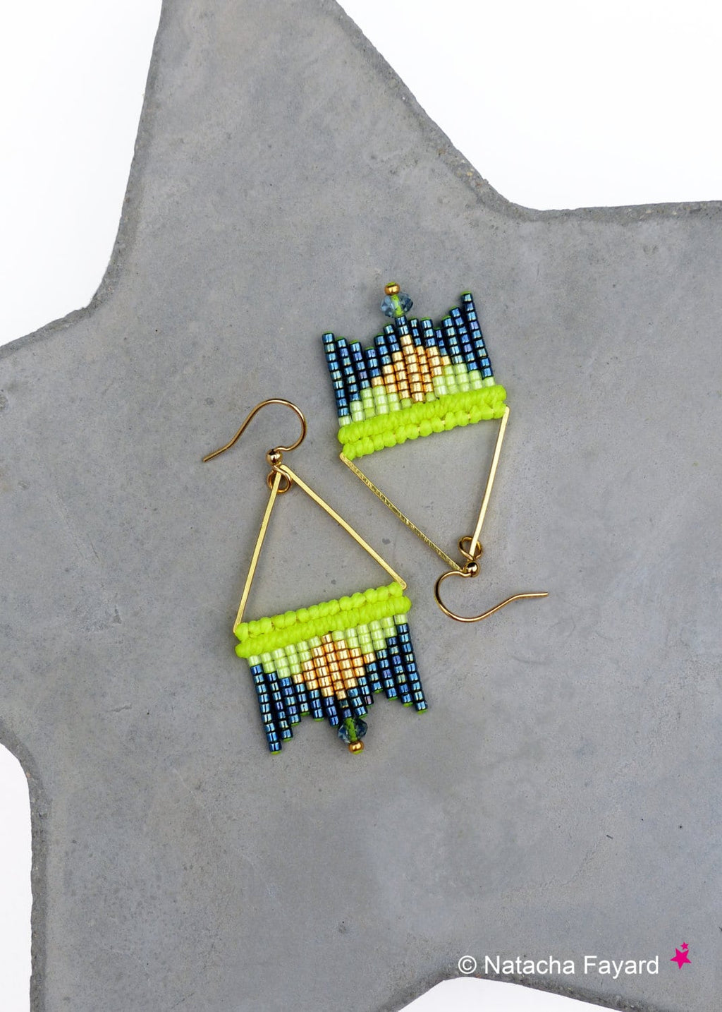 Peut inclure: Une paire de boucles d'oreilles triangulaires dorées avec des franges de perles vertes, dorées et bleues.