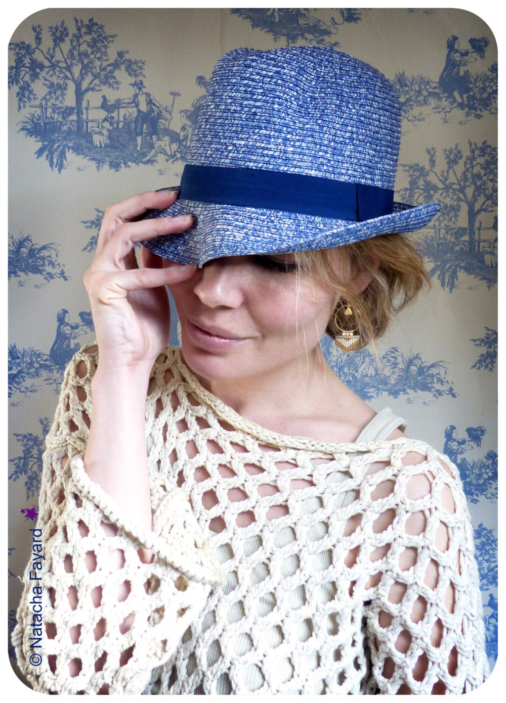 Peut inclure: Une femme portant un chapeau de paille bleu et blanc avec un bandeau bleu marine et un haut en crochet blanc.