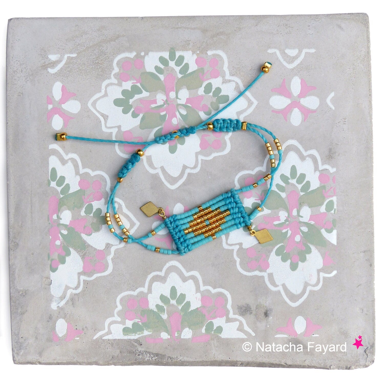Peut inclure: Un bracelet en perles turquoise et or avec un motif géométrique. Le bracelet est sur un fond gris avec un motif floral.